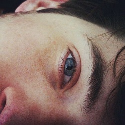La media cara de un chico con el ojo muy azul.